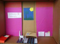 Praca przestrzenna wykonana z kartonu, przedstawiająca pokój dziecięcy, w którego wnętrzu naklejono meble wykonane z kolorowego papieru
