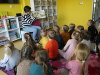 Bibliotekarka pokazuje dzieciom ilustrację w książce