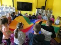 Przedszkolaki uczestniczą w zabawie ruchowej z wykorzystaniem chusty animacyjnej Klanza