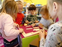 Dzieci budują domki z drewnianych klocków