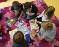 Grupa chłopców ogląda książki, siedząc na dywanie