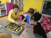 Troje dzieci gra w grę planszową