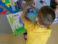 Chłopiec koloruje obrazek flamastrami